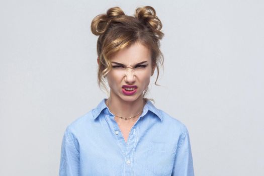 Roar! Anger woman shout at camera. Bad emotions and feelings. Isolated on gray background