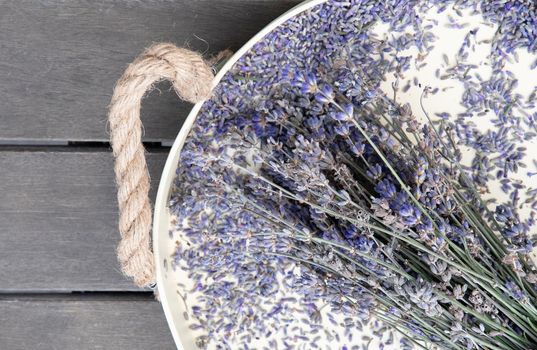 dry lavender on a beige tray on a wooden table top view. High quality photo
