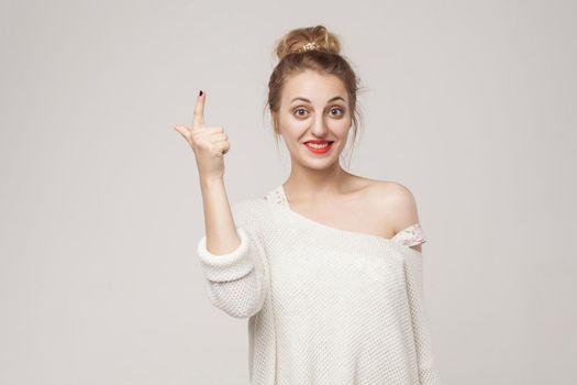 Great idea! Young adult woman finger up. Idea sign. Studio shot