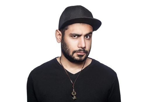 Portrait of young doubtful thinking man with black t-shirt and cap looking at camera with unsure eyes. studio shot, isolated on white background.