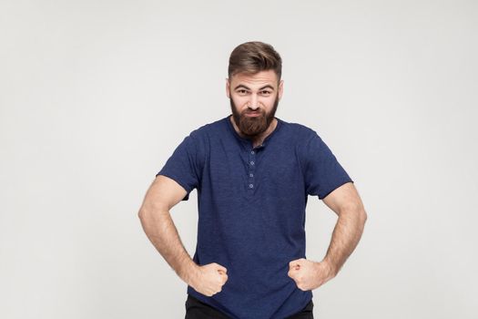 Popeye the Sailor style. Masculinity and strong bearded man posing and looking seriously at camera. Studio shotm gray background