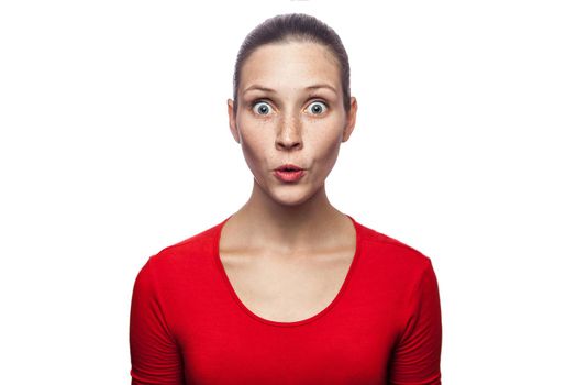 Portrait of happy surprised woman in red t-shirt with freckles. looking at camera excited with big eyes, studio shot. isolated on white background.