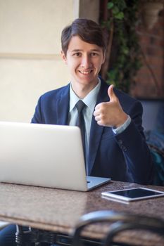young man in business suit sitting in office and working