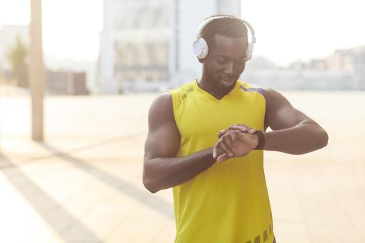 Closeup portrait of african man with berfect body. After jogging counts how many calories burned