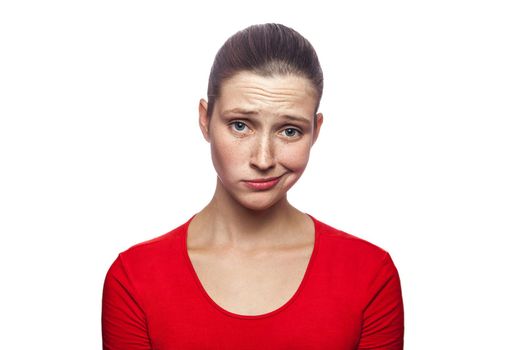 Portrait of sad unhappy woman in red t-shirt with freckles. studio shot. isolated on white background. .