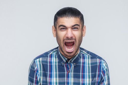 Mans roar! The angry businessman, screaming with closed eyes. Indoor, studio shot. Gray background