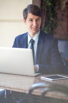 young man in business suit sitting in office and working