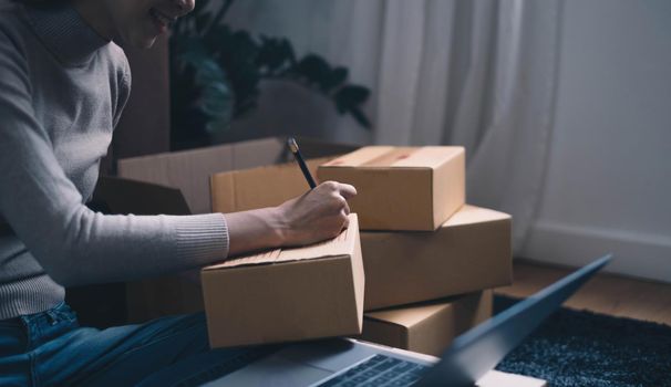 Starting small businesses SME owners female entrepreneurs Write the address on receipt box and check online orders to prepare to pack the boxes, sell to customers, sme business ideas online..