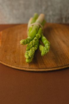 branches of fresh green asparagus on a wooden background, top view