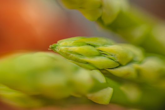 branches of fresh green asparagus on a wooden board, brown background, close-up. macro photography.