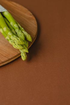 branches of fresh green asparagus on a wooden background, top view