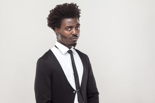 Unhappy man looking at camera. Studio shot, gray background