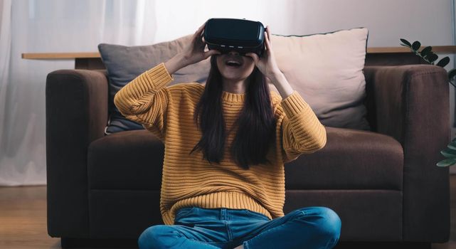 Asian woman play VR game for entertain at home, asian woman joyful in house on holiday. Happy woman playing metaverse VR technology concept..