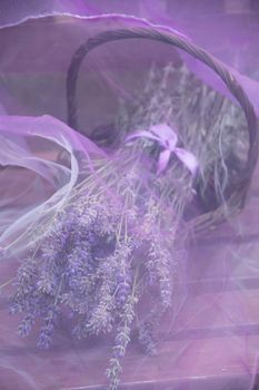 lavender bouquet in a wicker basket under transparent purple chiffon. High quality photo