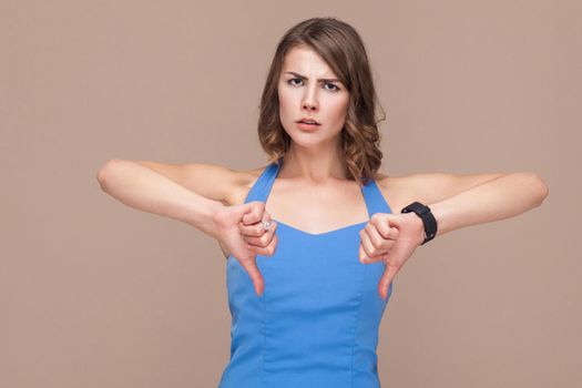 Business woman demonstrate dislike at camera. Studio shot, light brown background