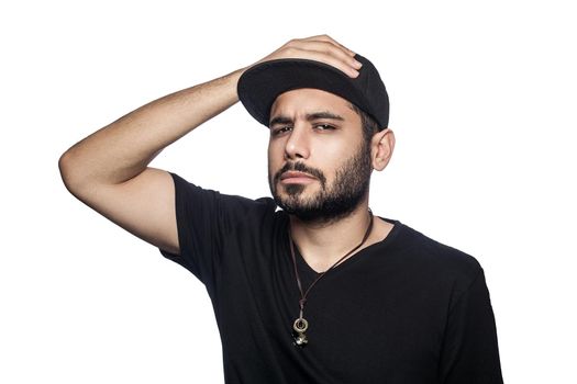 Portrait of young beautiful sexy man with black t-shirt and cap posing and looking at camera. studio shot, isolated on white background.