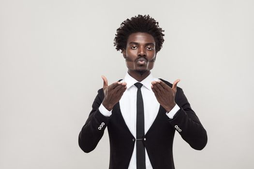 African man send air kissing at camera with love . Studio shot, gray background