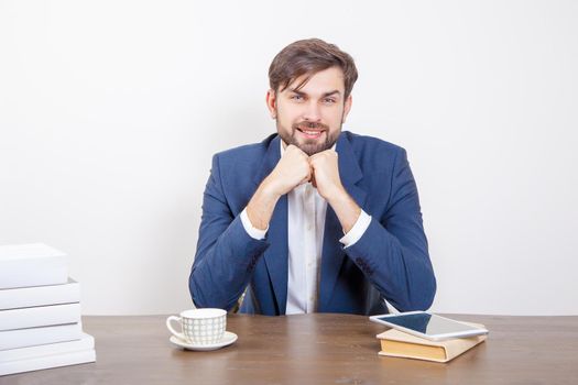 Technology, people and business concept - handsome man with beard and brown hair and blue suit and tablet pc computer and some books in the office, looking at camera with smile. .Isolated on white background. .