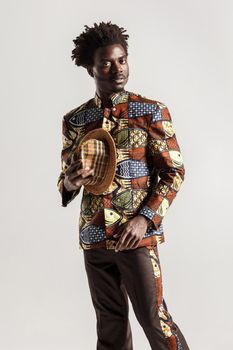 Richly and luxury african man in traditional clothes. Indoor, isolated on gray background