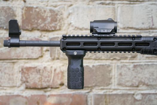 Weapon and military equipment for self defence. Gun isolated on old rusty brick wall background. front grip for a shot gun. Handgun ready to use.