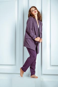 Full length shot, of fashion model in oversize violet suit. Studio shot