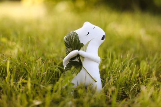Eco-friendly cute handmade toy bear on grass at sunny summer day