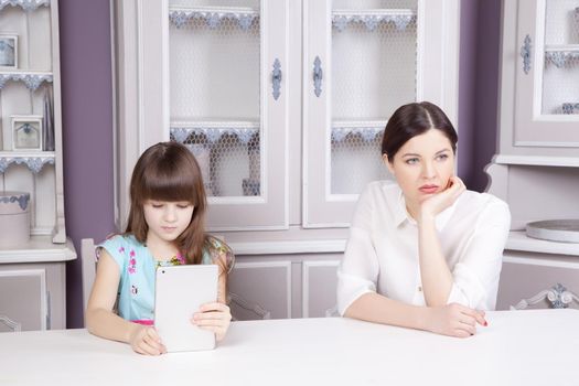 Mother and daughter quarrel because of overuse the tablet phone . Social problem between parents and children. Studio shot..