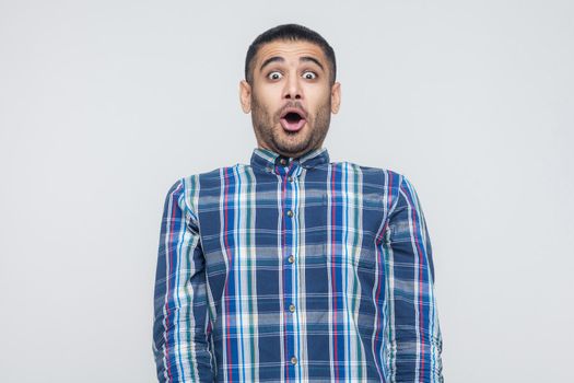Wondered business man. Looking at camera with shocked face and big eyes and open mouth. Isolated on gray background, studio shot. Indoor