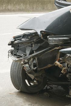 black car damaged by a road accident .