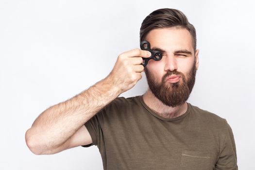Young man holding and playing with fidget spinner. studio shot on white background. .