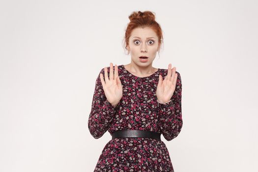 Human face expressions and emotions. Redhead young woman hands up and have a shocked face. Studio shot