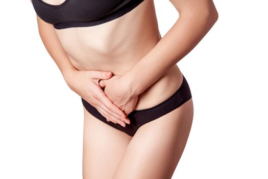 Closeup view of a young woman with stomach pain or digestion or period cycle on white background.