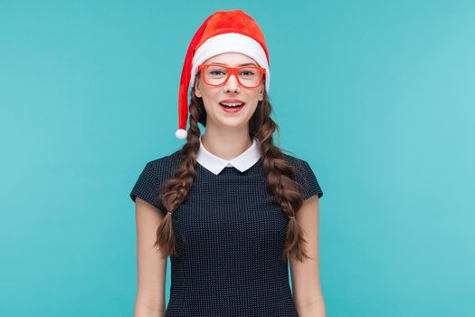 Christmas concept, new year. Cute businesswoman with pigtails looking at camera and smiling. Indoor shot, green background