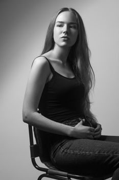 Portrait of proud woman, looking looking at camera. Studio shot, isolated on gray background