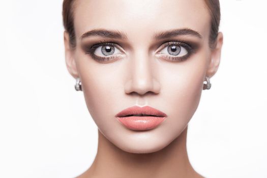 Portrait of beautiful young brunette woman with smoky eyes makeup and natural lips looking at camera. beauty, makeup health and skin care concept. indoor isolated on white background.