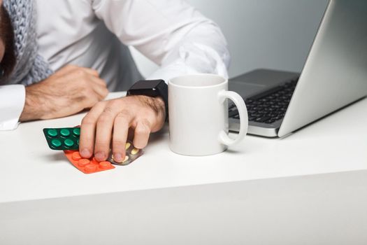 Drug, medication in the work station. Illness manager in white shirt are sitting in office is snoozing at his work place near laptop. Indoor, studio shot, , isolated, close up