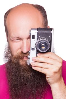 The portrait of bald bearded man photographer with pink t shirt holding classic camera. isolated on white background. studio shot.