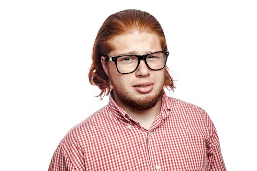 doubting confused bearded readhead businessman with red shirt and freckles looking at camera. studio shot isolated on white.