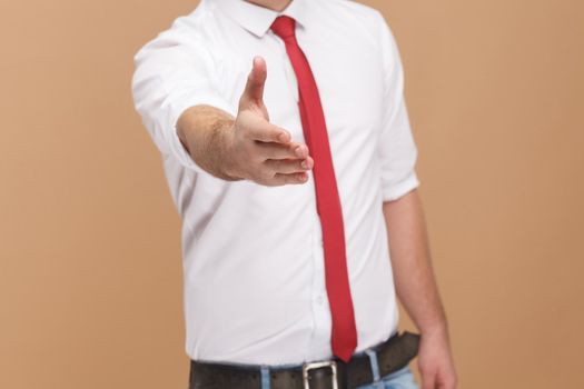 man shows handshake sign and welcome new job. Business people concept, good and bad emotion and feelings. Studio shot, isolated on light brown background