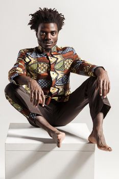Closeup pfoto of despair african man looking at camera. Indoor, isolated on gray background