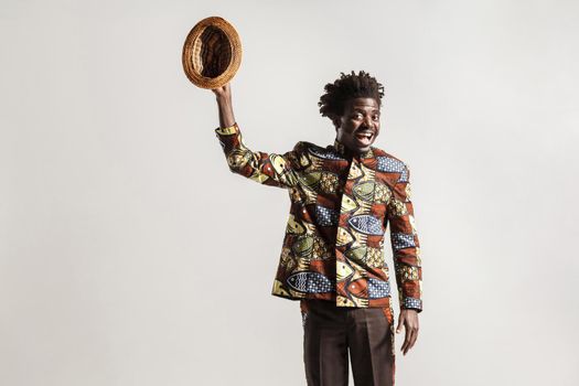 Crazy and funny african man toothy smiling , looking at camera. Indoor, isolated on gray background