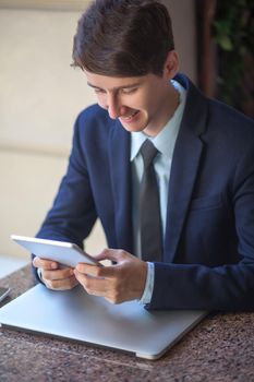 young man in business suit sitting in office and working
