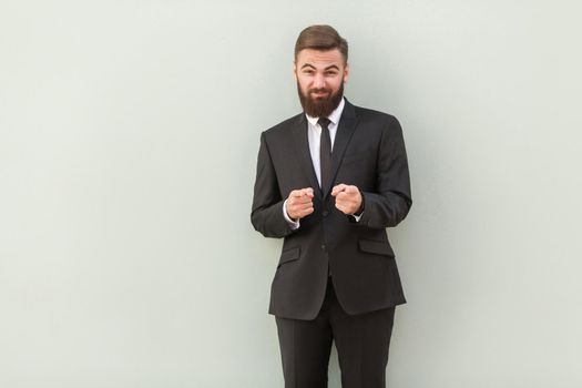 Hey you! Succes broker pointing fingers at camera. Career concept. Studio shot, gray background