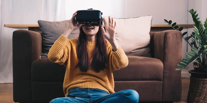 Asian woman play VR game for entertain at home, asian woman joyful in house on holiday. Happy woman playing metaverse VR technology concept..