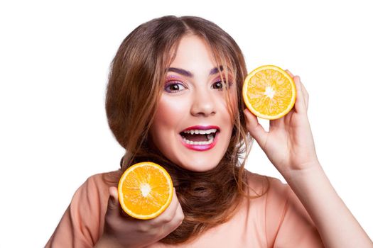 Young beautiful funny girl with orange slice and makeup and hairstyle looking at camera. studio shot, isolated on white background. .