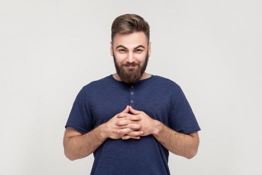 Сunning businessman, crossed hands and looking slyly at camera. Indoor, studio shot