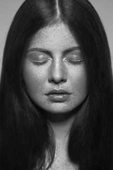 Beautiful fashion model with freckles, makeup and dark hairstyle. .Black and white photography.