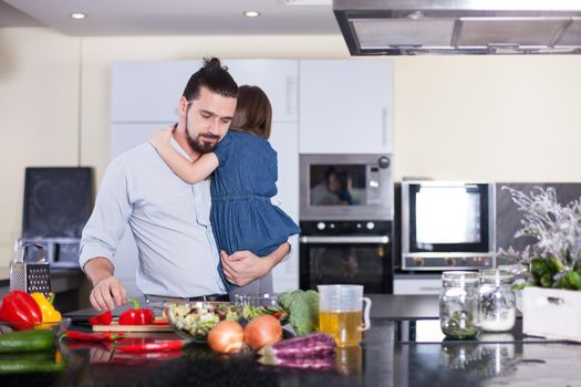 Father teaches his daughter to cook at home in the kitchen.