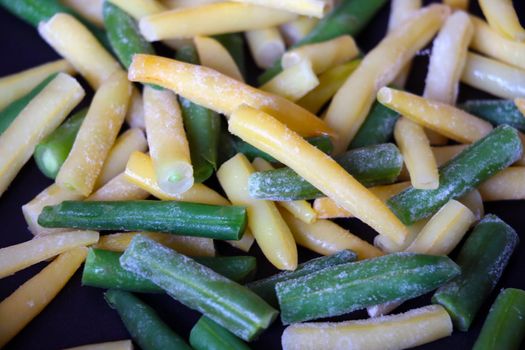 Colored yellow-green beans in a frying pan. Cooking