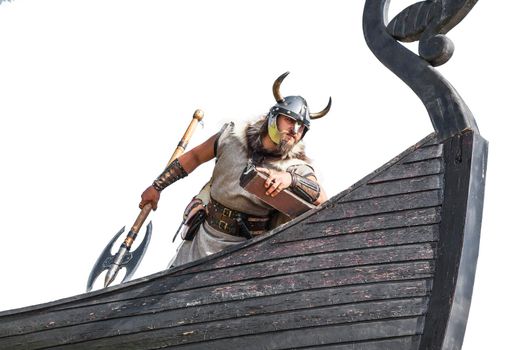 Strong Viking on his ship. Angry man with historical weapon and helmet on ship looking. and ready to attack.